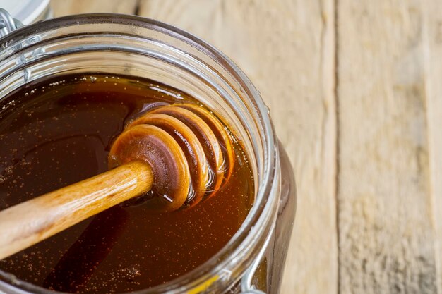 Jar of fresh honey with honey dipper