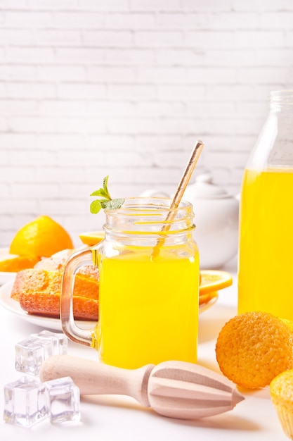 Jar of fresh lemonade. Sliced lemon on background.