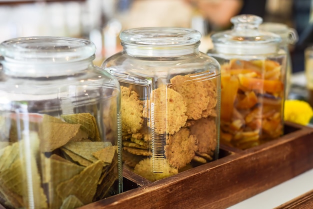 Jar full of circle homemade cookies cones and dried fruits with copy space