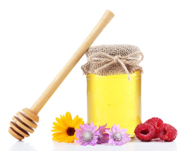 Jar full of delicious fresh honey and wild flowers, on white