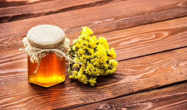 Jar of golden honey on an old table.