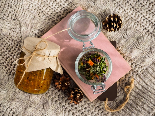 A jar of gooseberry jam and a book on a wool blanket.