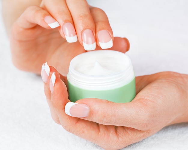 Jar of hand cream in female hands