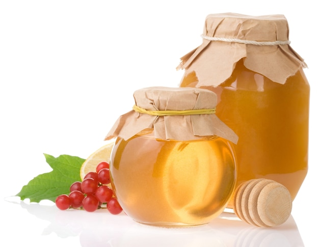 Jar of honey and fruit isolated on white