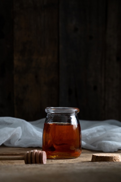  jar of honey stands on a wooden background