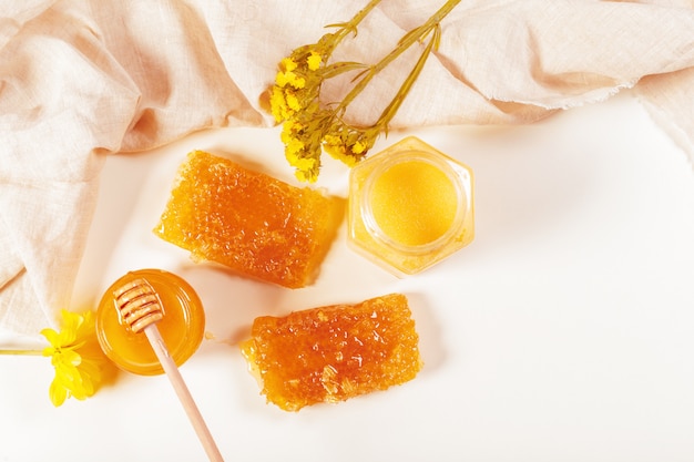 Jar of honey and stick isolated on white 