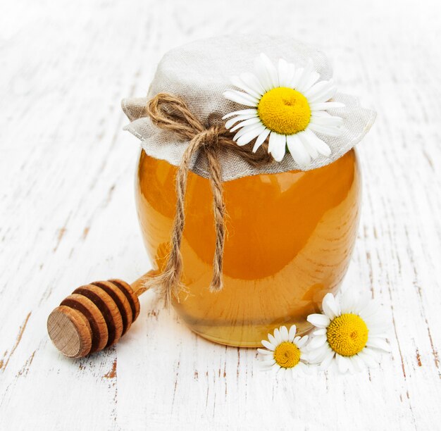 Photo jar of honey with camomile