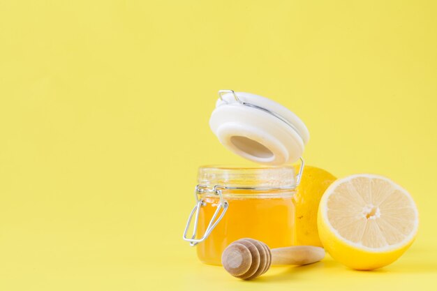꿀 항아리는 나무로되는 숟가락과 레몬