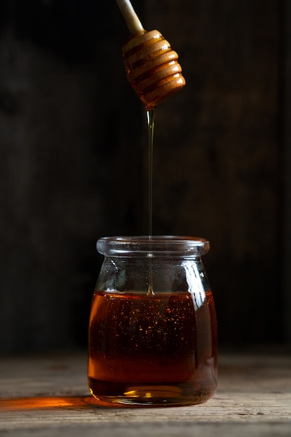  jar of honey on a wooden surface