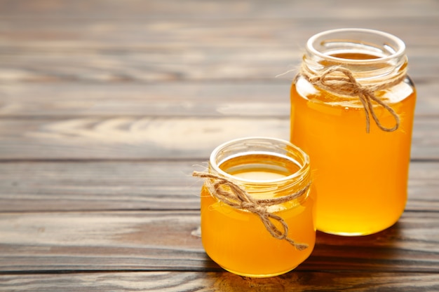 Jar of honey on wooden table top view