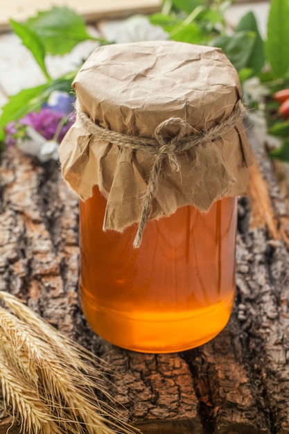 Jar of liquid honey on wooden surface