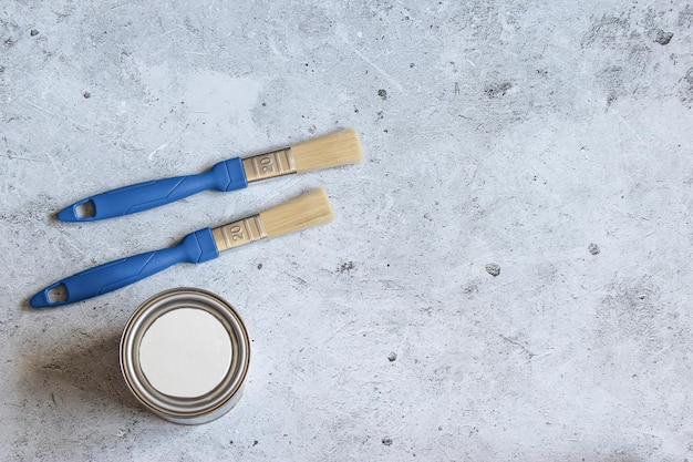 Jar paint pot and paint brushes on a concrete background Concept of repair and renovation