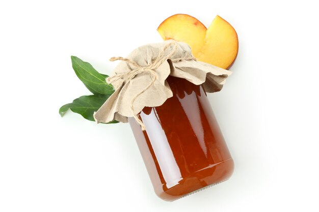 Jar of peach jam and ingredient isolated on white background