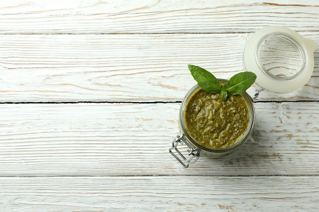 Jar of Pesto sauce on white wooden background