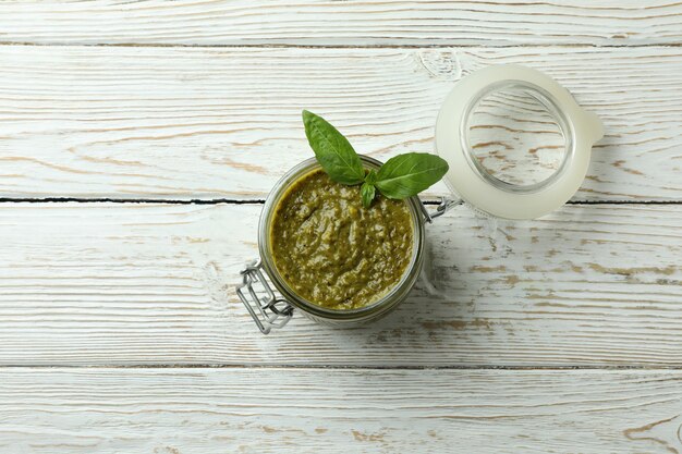 Jar of Pesto sauce on white wooden background