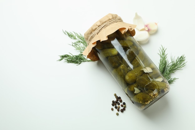 Jar of pickles and ingredients on white background