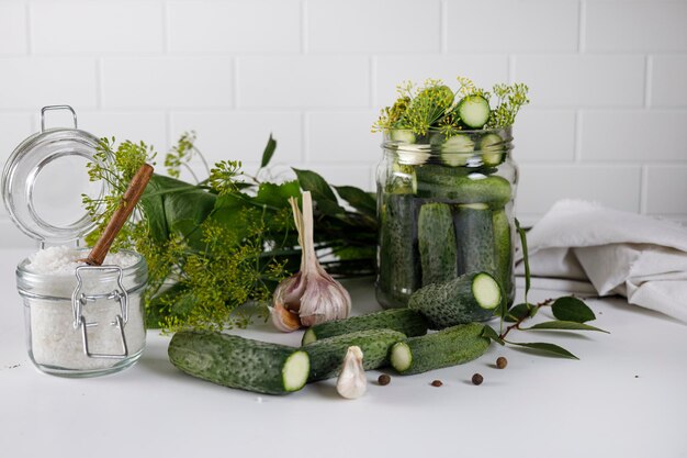 a jar of pickles Nearby are the ingredients for salting