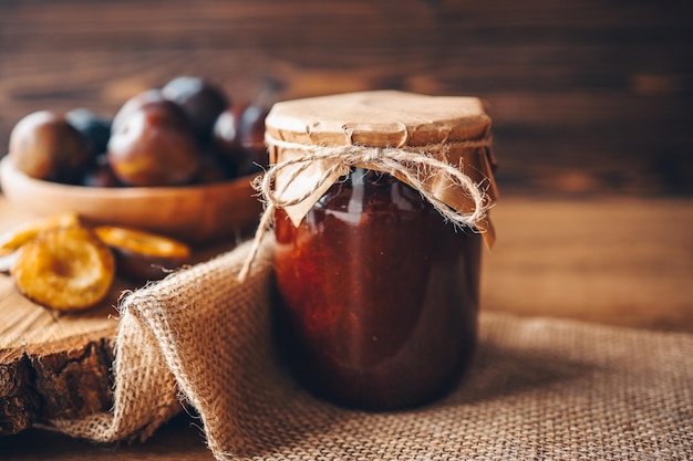 Jar of plum jam with craft decor