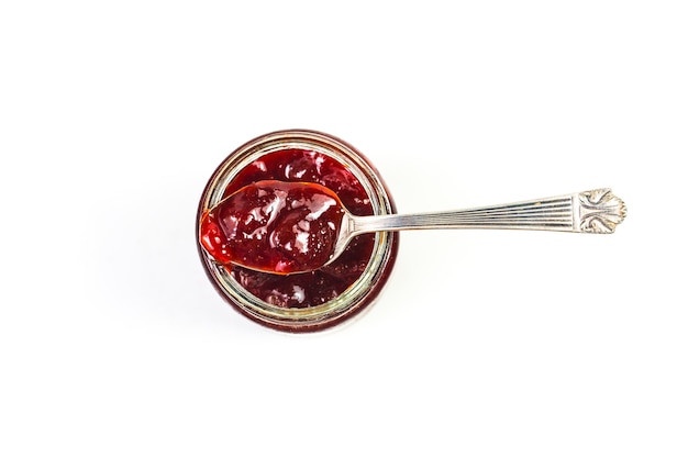 Jar of strawberry jam on  wooden background from top view 