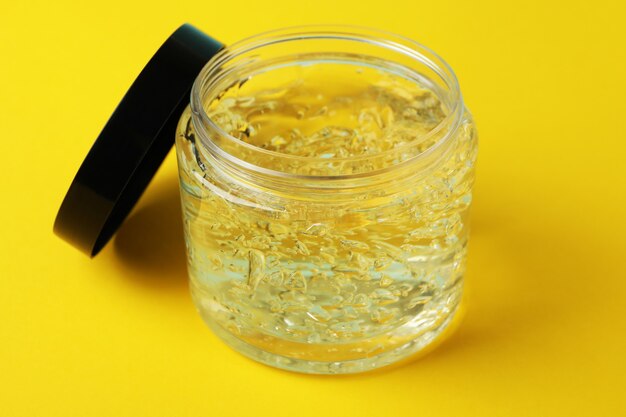 Jar of styling gel on yellow isolated background, close up