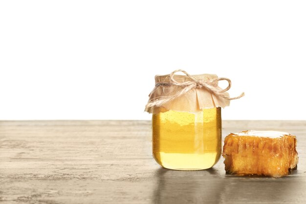 Photo jar of sweet honey on table against white background