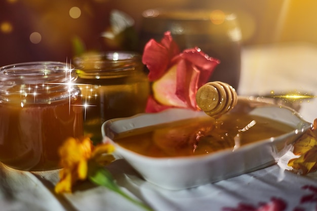 A jar of sweet honey on a table from the garden with apples