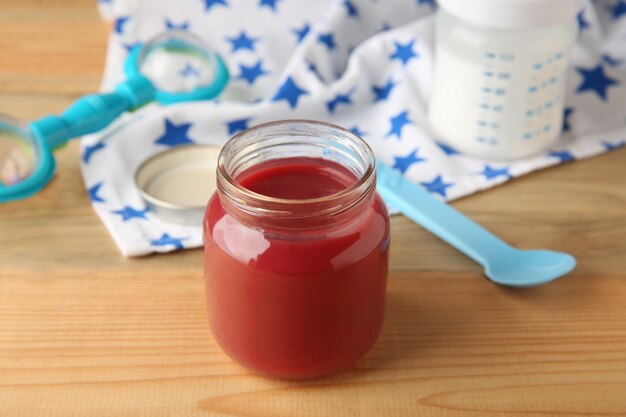 Jar of tasty baby food on wooden table