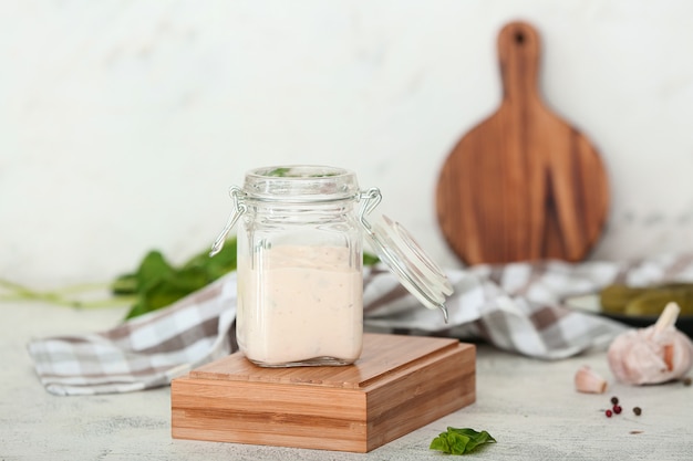 Jar of tasty sauce on white table