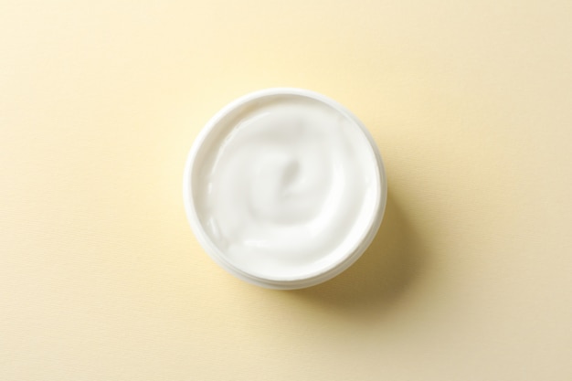 Photo jar of winter cream for skin on yellow