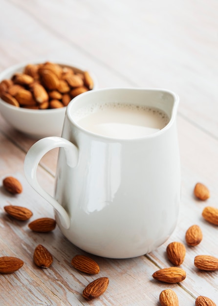 Jar with almond milk and almonds on the table