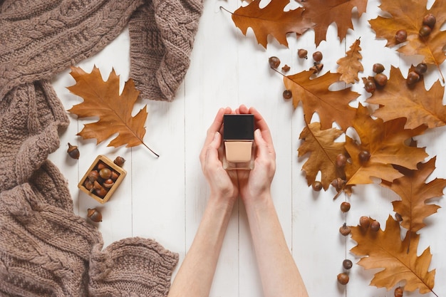 Vaso con un cosmetico nelle mani della donna vista dall'alto concetto di cosmetici di bellezza naturale bellezza autunnale