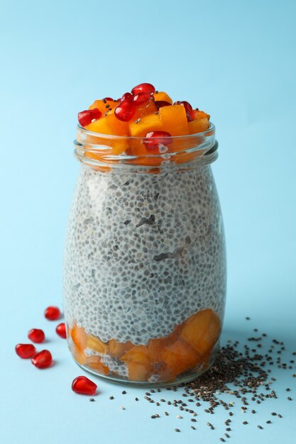 Jar with delicious chia pudding on blue