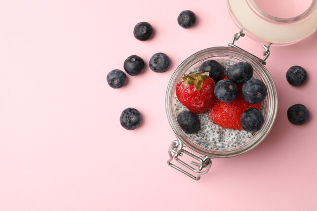 Jar with delicious chia pudding on pink