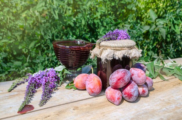 Jar with fresh plum over wood background