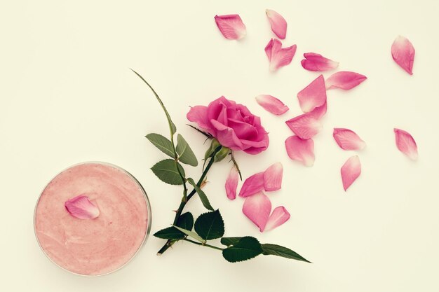 Jar with a homemade moisturizing beauty cream and pink rose flower Top view xD