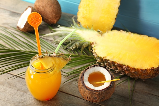 Jar with pineapple cocktail on wooden table