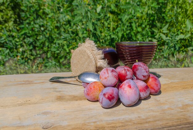 Jar with plum  over wood background