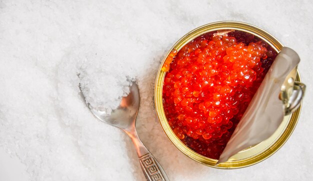 Vaso con caviale rosso e un cucchiaio di sale