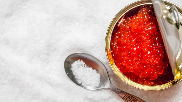 Jar with red caviar and a spoon of salt