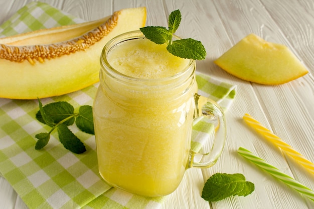 Jar with yellow melon smoothie close up