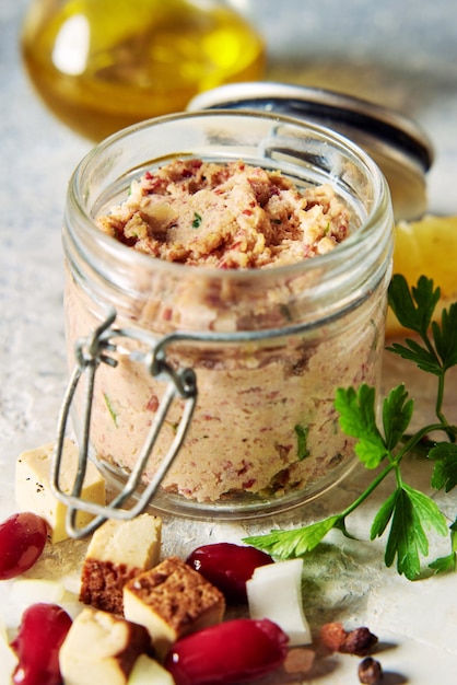 Jar of yummy vegan liverwurst pate served on table with cheese and beans