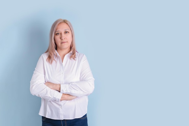 Jaren '40 vrouw staat op een blauwe achtergrond met haar armen gekruist