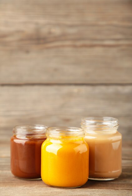 Jars of baby puree on grey wood