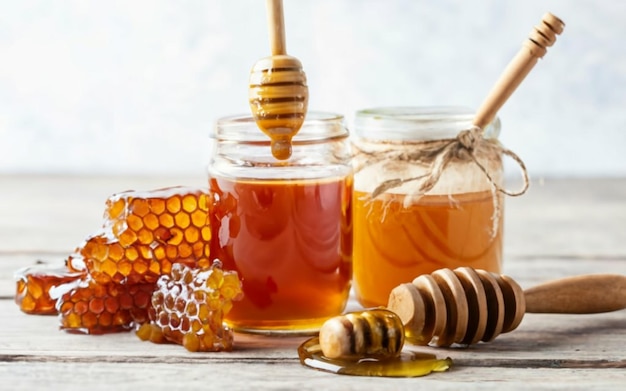 Jars of honey on a table with pieces of honeycomb next to them