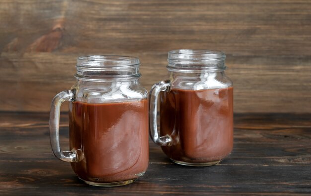 Jars of hot chocolate on wooden table