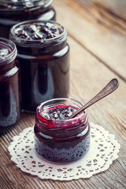 Photo jars of jam on wooden kitchen table retro toned