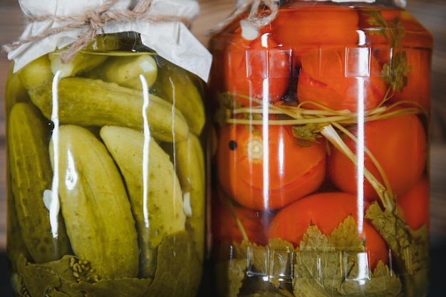 Photo jars of pickled vegetables on rustic wooden background