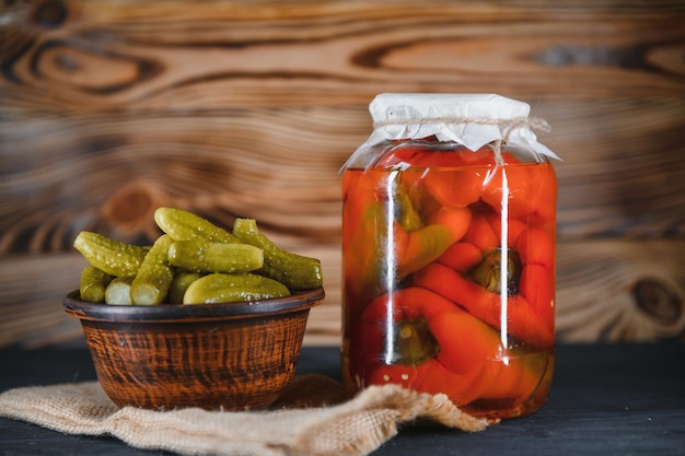 Jars of pickled vegetables on rustic wooden background