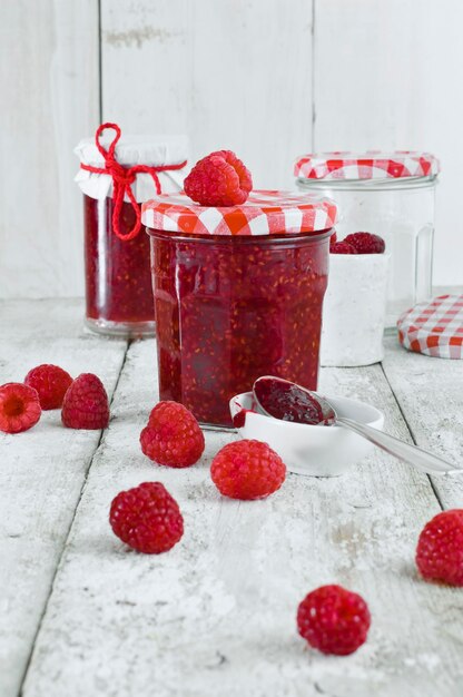 Jars of raspberry jam and raspberries