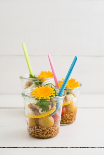 Jars of salad to go with spelt, cherry tomatoes, zucchini, walnuts, parsley, mozzarella and edible f